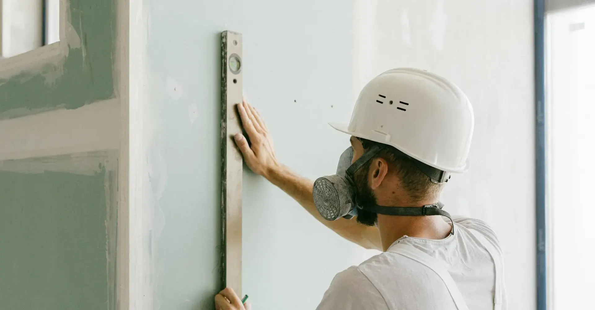 Technician checking a wall with a level during fit-out works