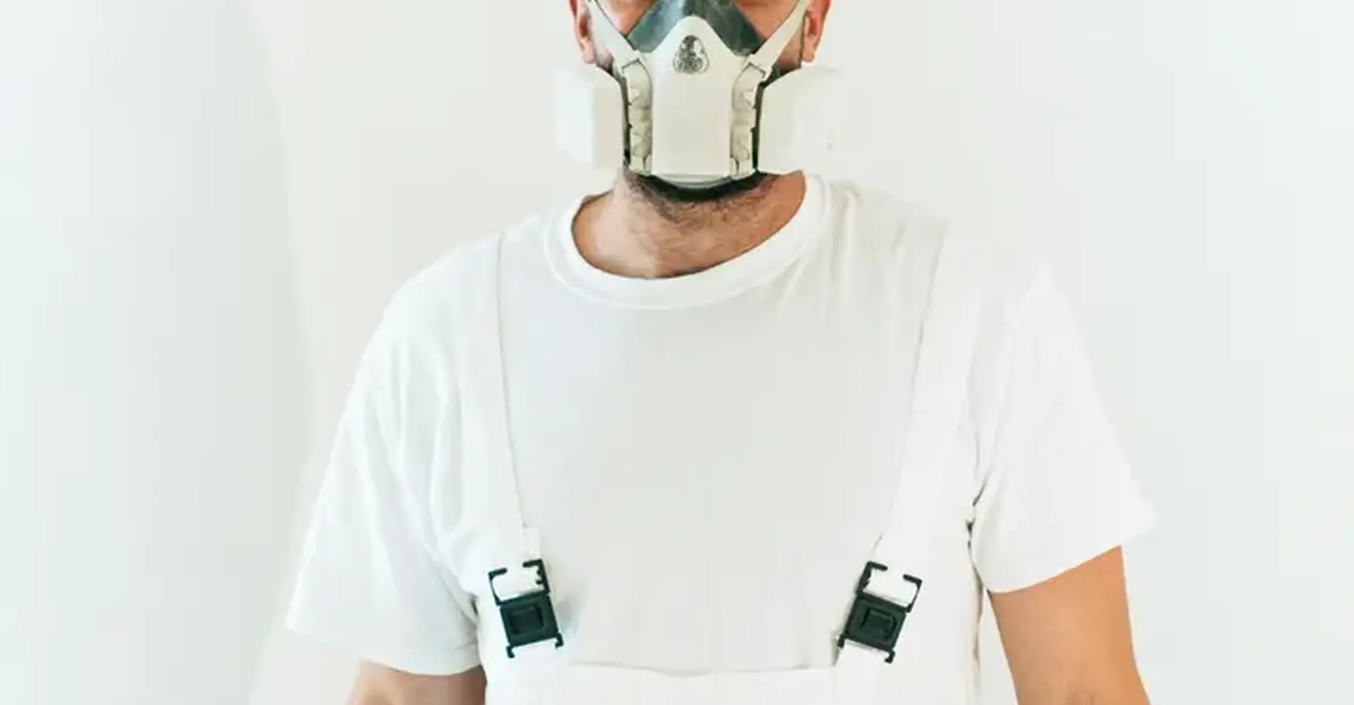 Technician in respirator and protective clothing for insulation work