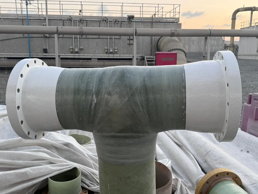 Flanged GRP tee fitting with laminated joints