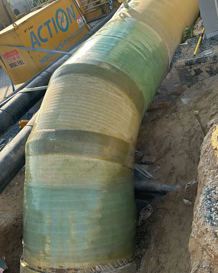 Laminated GRP pipe elbow joint in an excavation