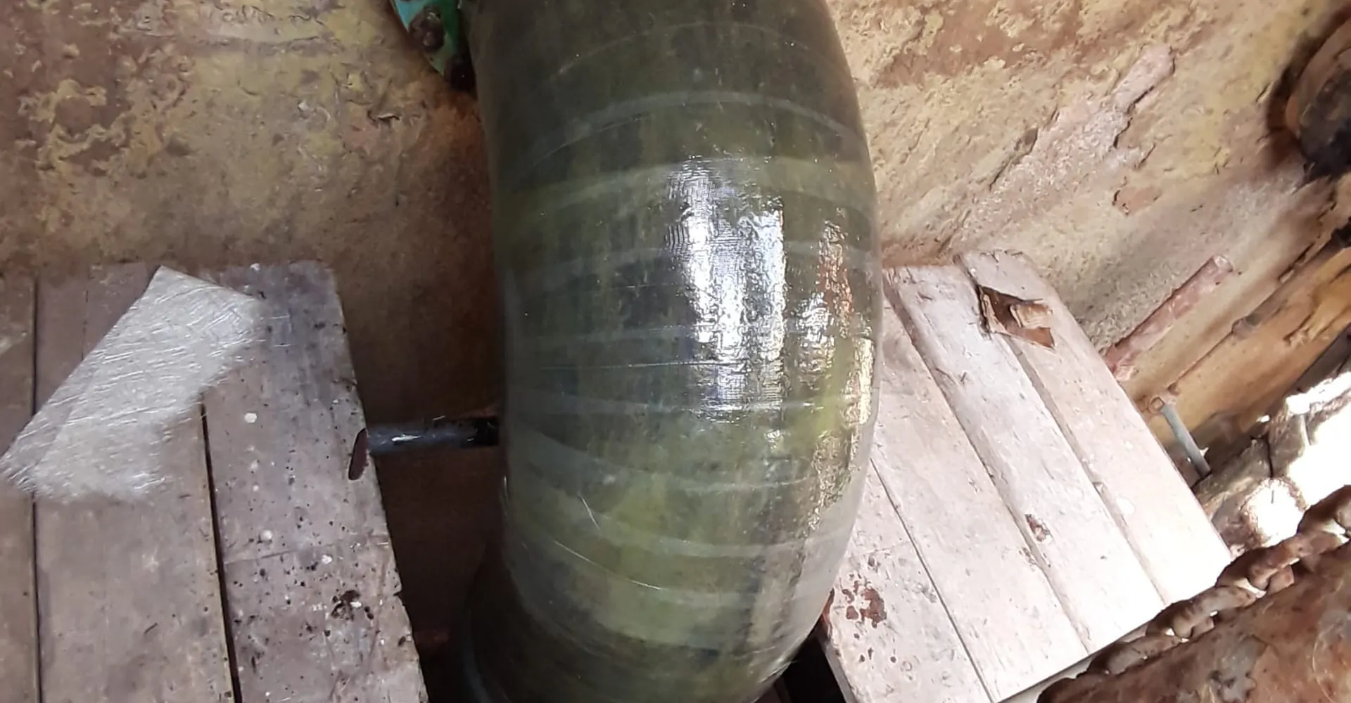 Laminated GRP pipe bend with flange in a pit